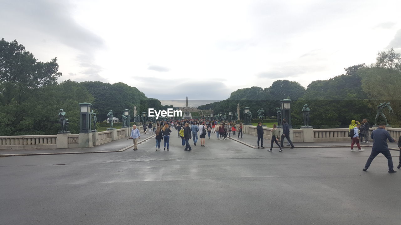 PEOPLE WALKING ON ROAD IN PARK