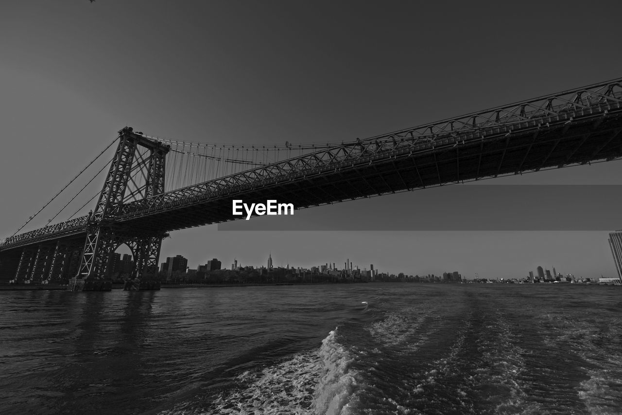 Suspension bridge over river against sky