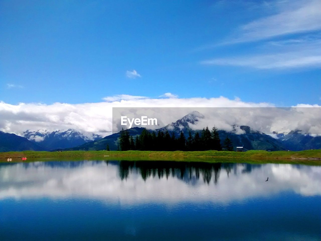 Scenic view of lake zell by mountains against sky