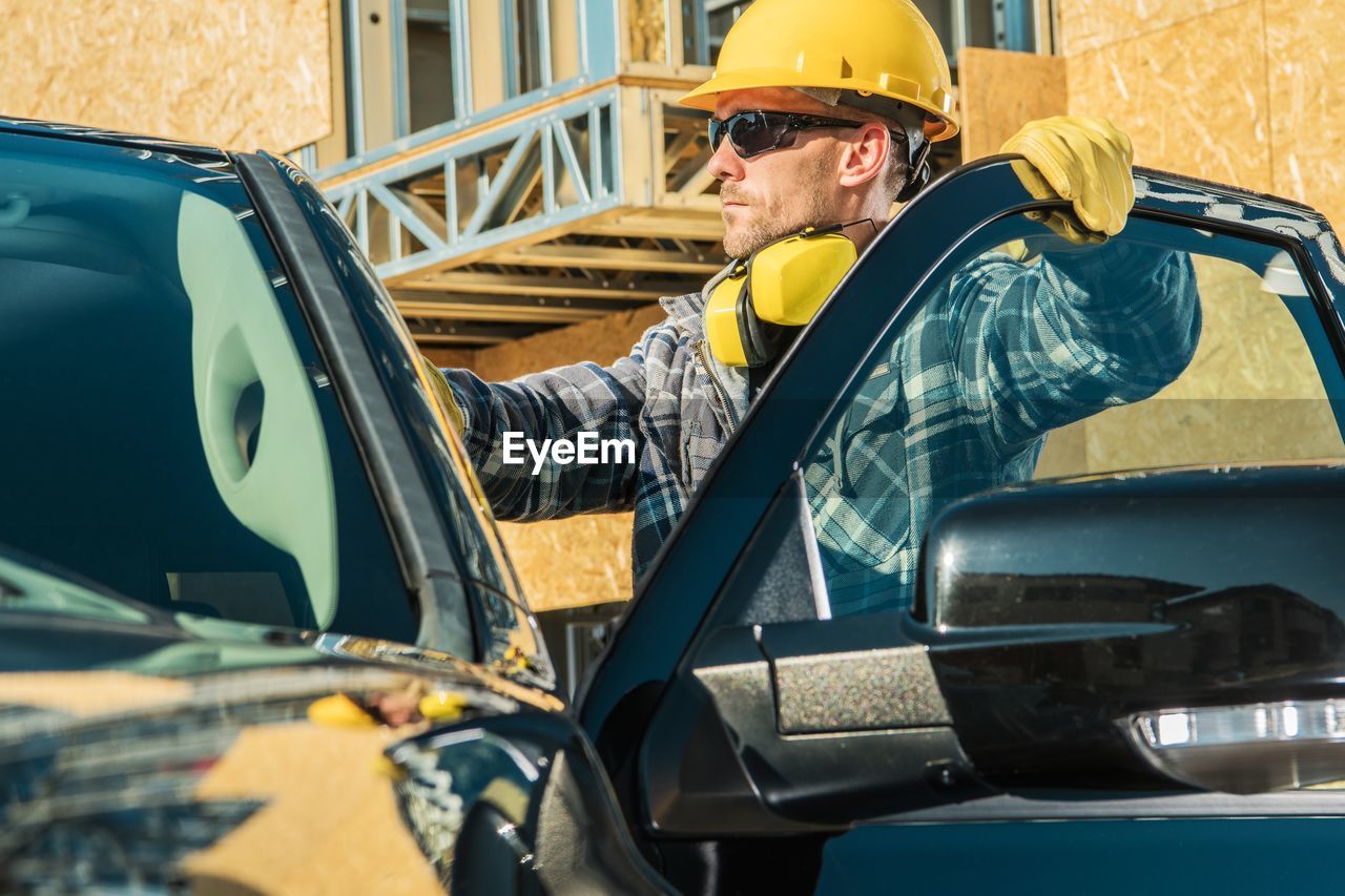 SIDE VIEW OF MAN WORKING ON CAR