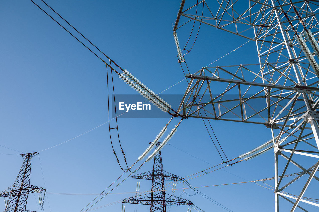 low angle view of electricity pylon against blue sky