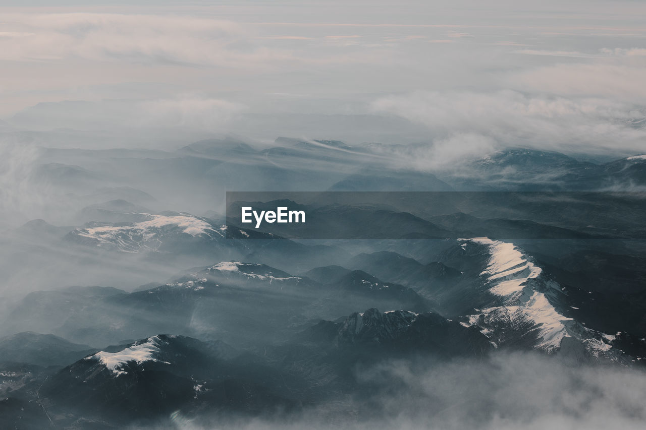 Aerial view of mountains against cloudy sky