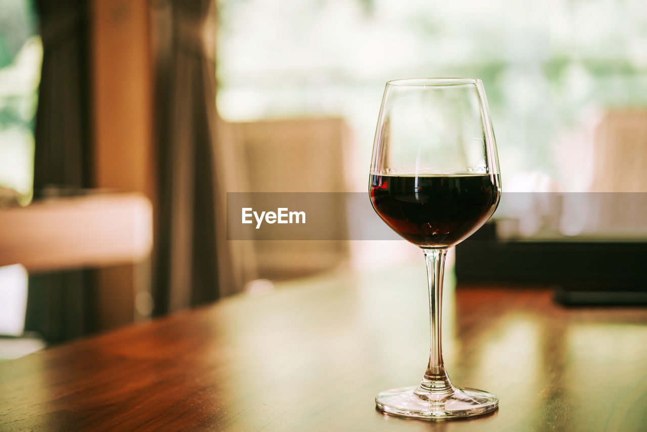 CLOSE-UP OF GLASS OF WINE ON TABLE