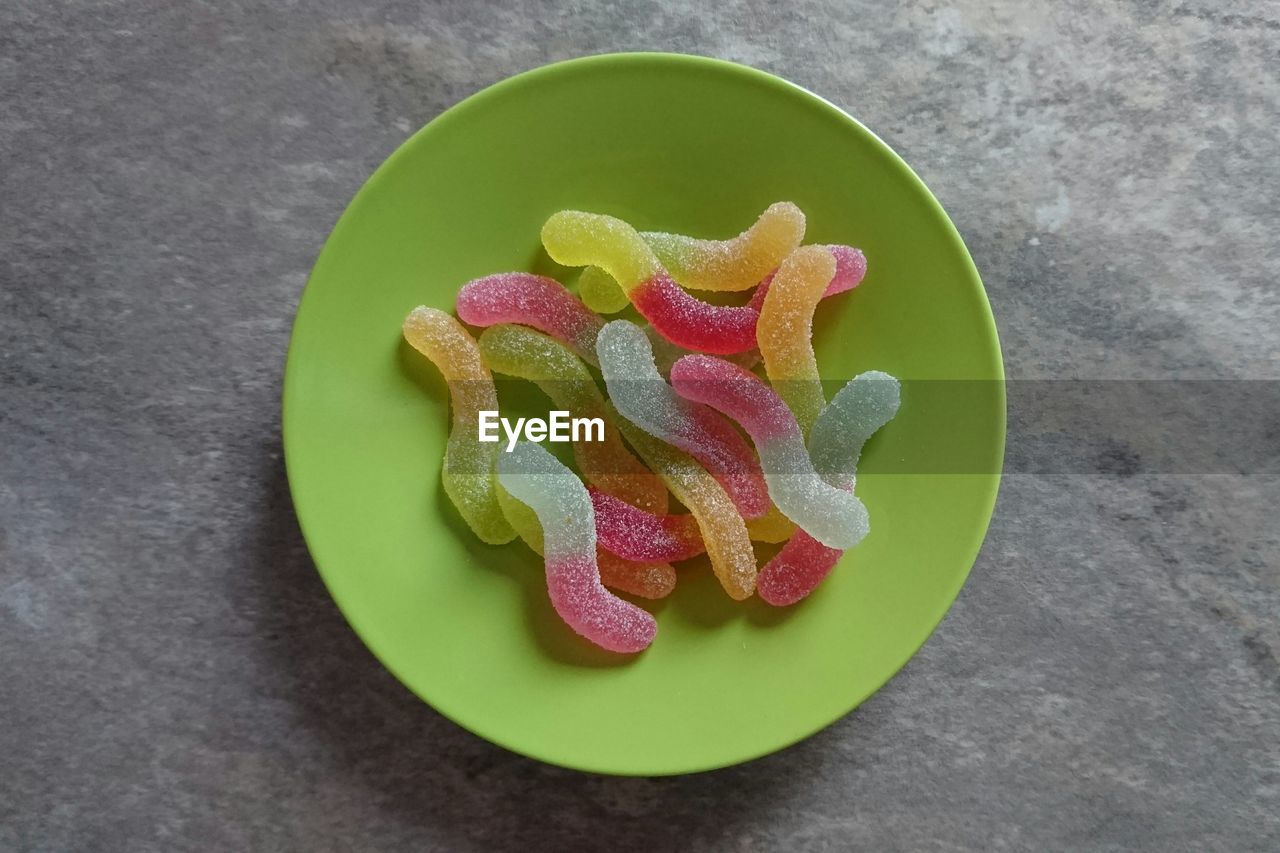 Directly above view of colorful gummy candies in plate on table