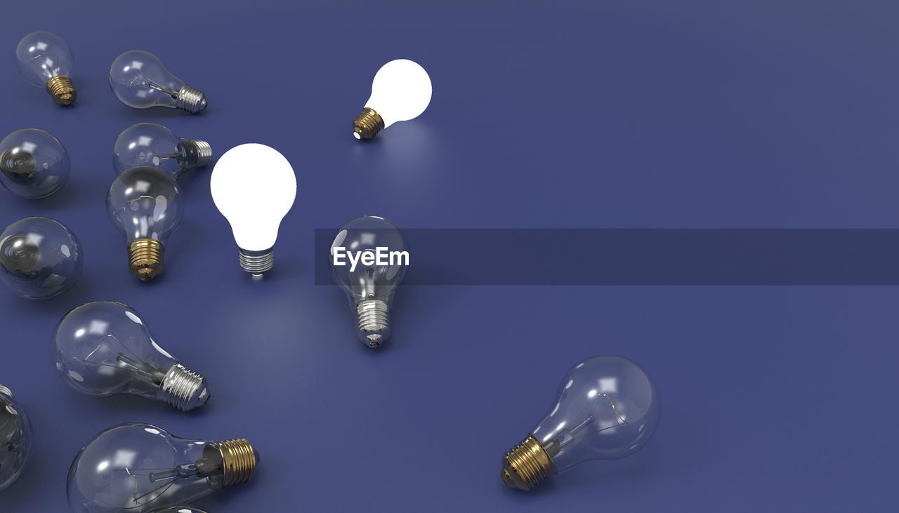 High angle view of light bulbs over blue background