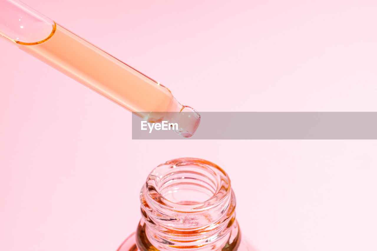studio shot, healthcare and medicine, indoors, pink, research, container, bottle, science, copy space, scientific experiment, education, glass, close-up, no people, food and drink, medicine, orange, water, cut out