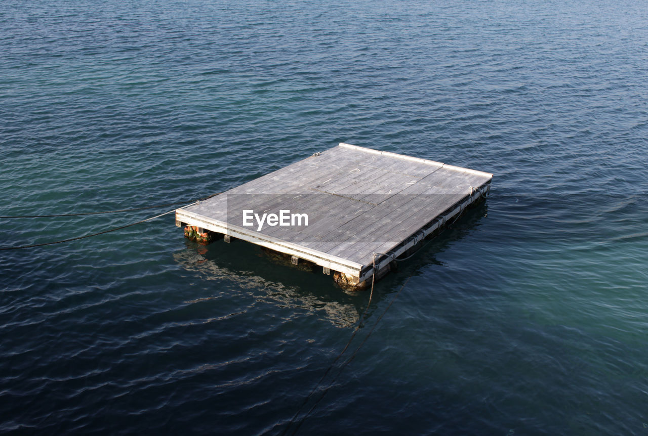 High angle view of wooden raft floating on water in sea