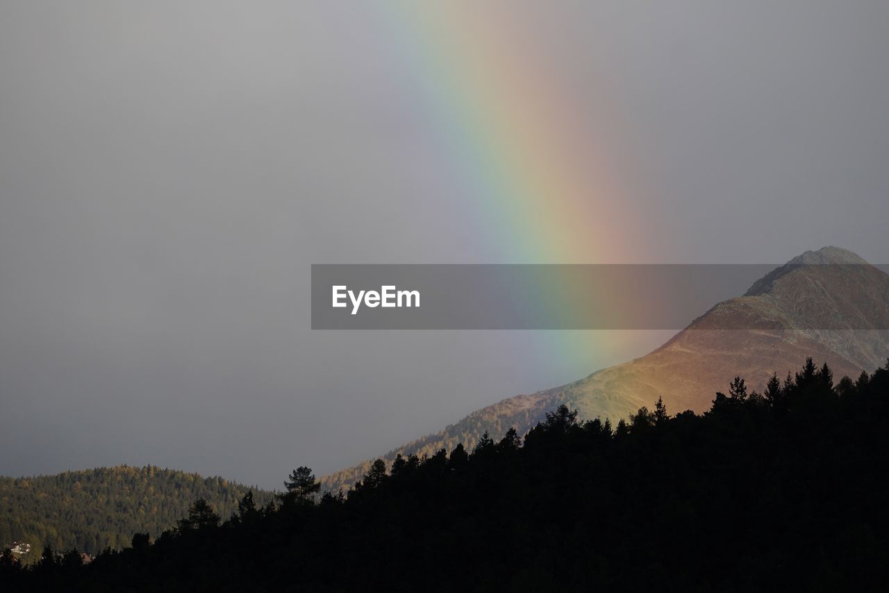 RAINBOW OVER MOUNTAINS AGAINST SKY