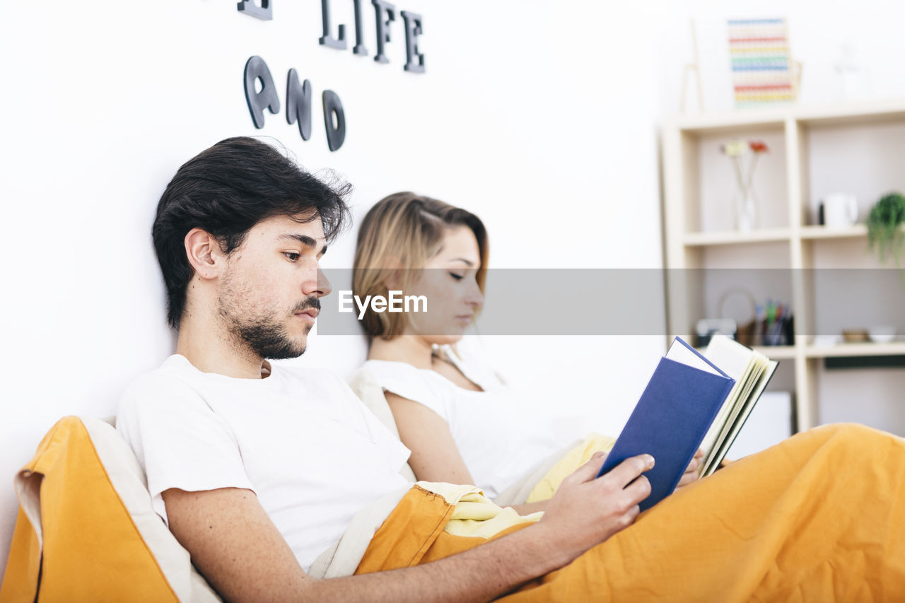 YOUNG COUPLE SITTING ON LAPTOP