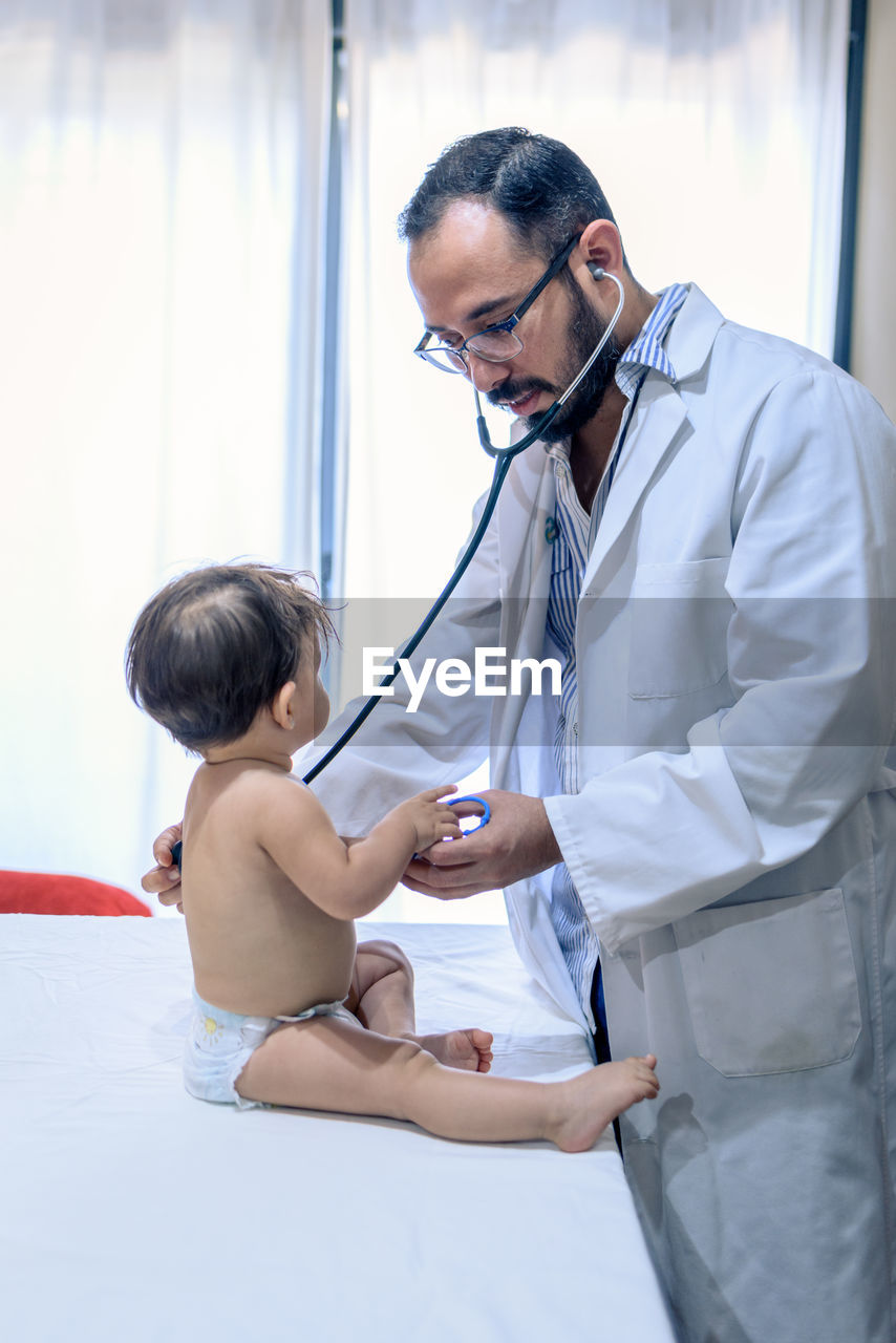 Doctor observing a one-year-old baby