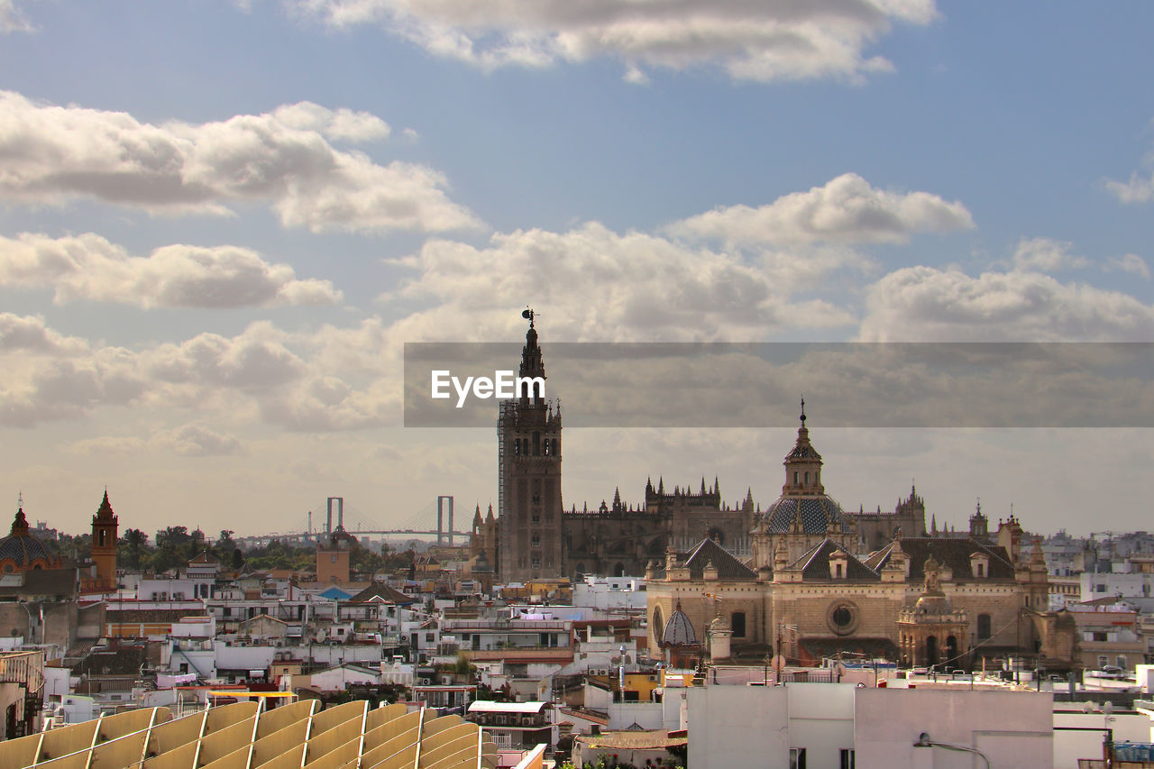 BUILDINGS IN TOWN AGAINST CLOUDY SKY