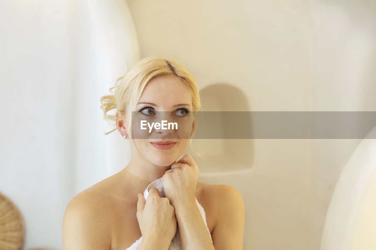 Smiling woman looking away while sitting at home