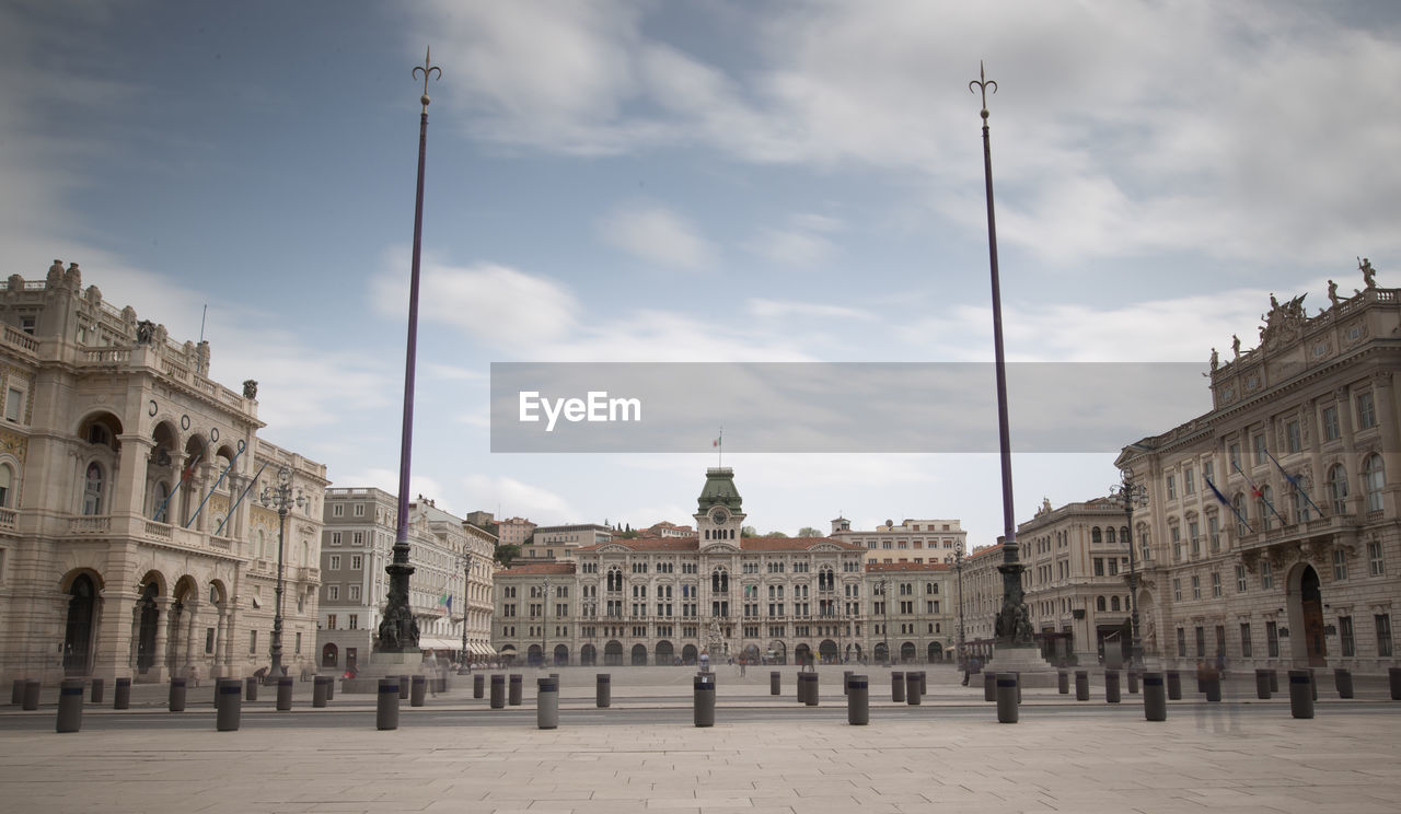 Buildings in city against cloudy sky