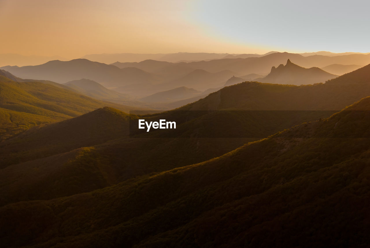 Scenic view of mountains against sky at sunset