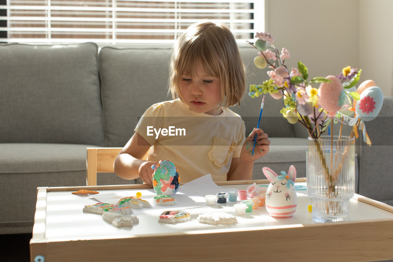 boy playing with toy while sitting on table