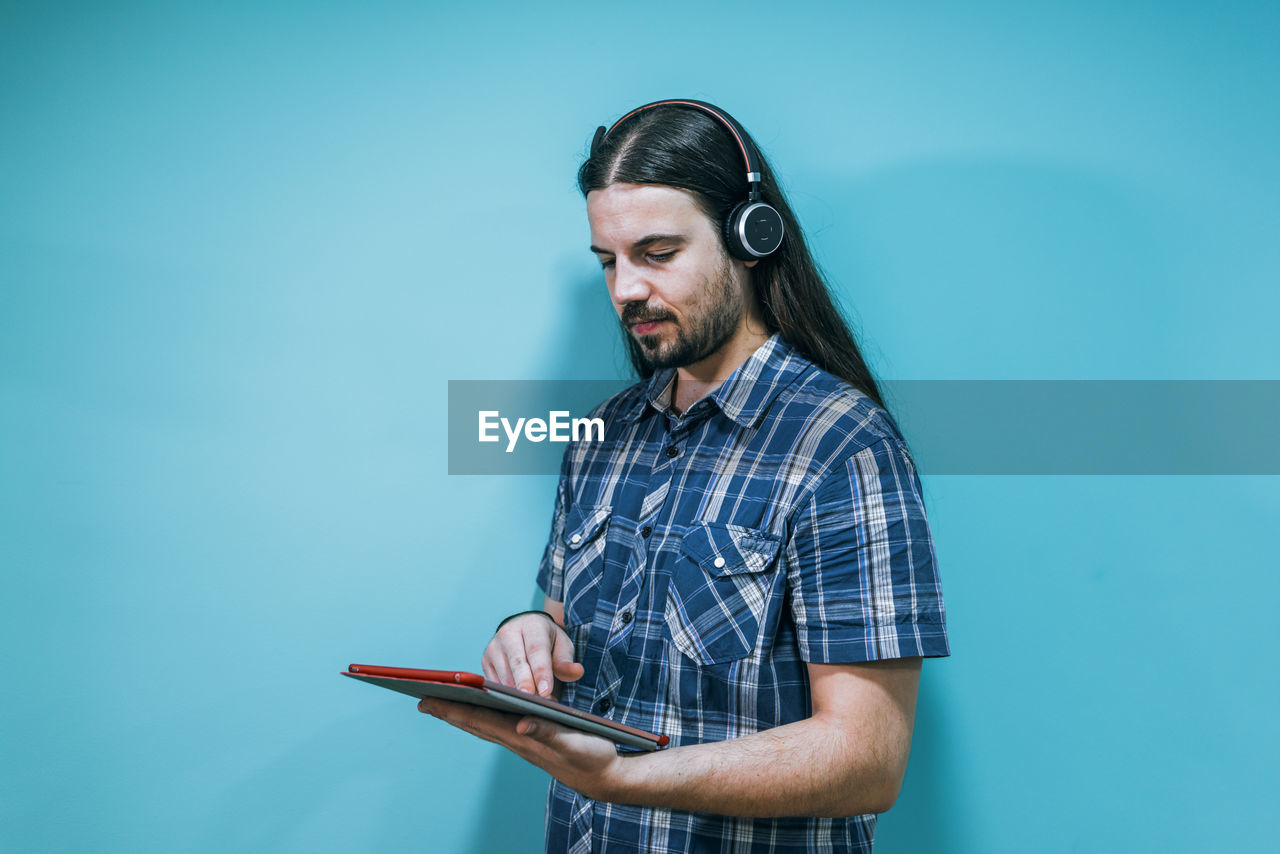 Portrait of a young businessman with tablet and headphones on a