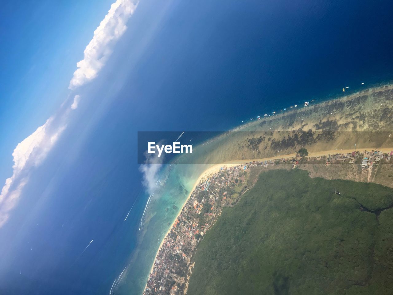 Aerial view of beach against cloudy sky