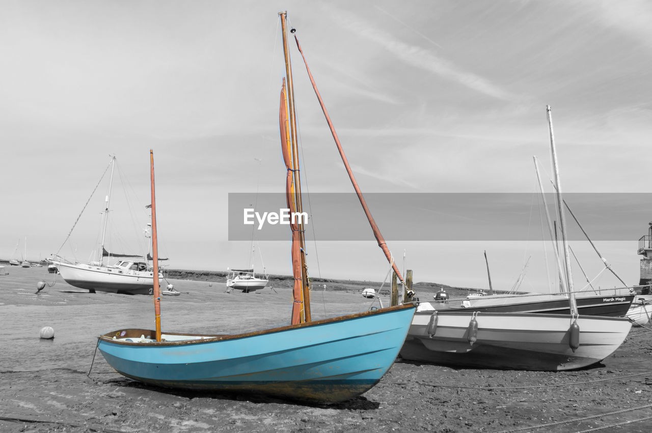 BOAT MOORED ON SEA AGAINST SKY