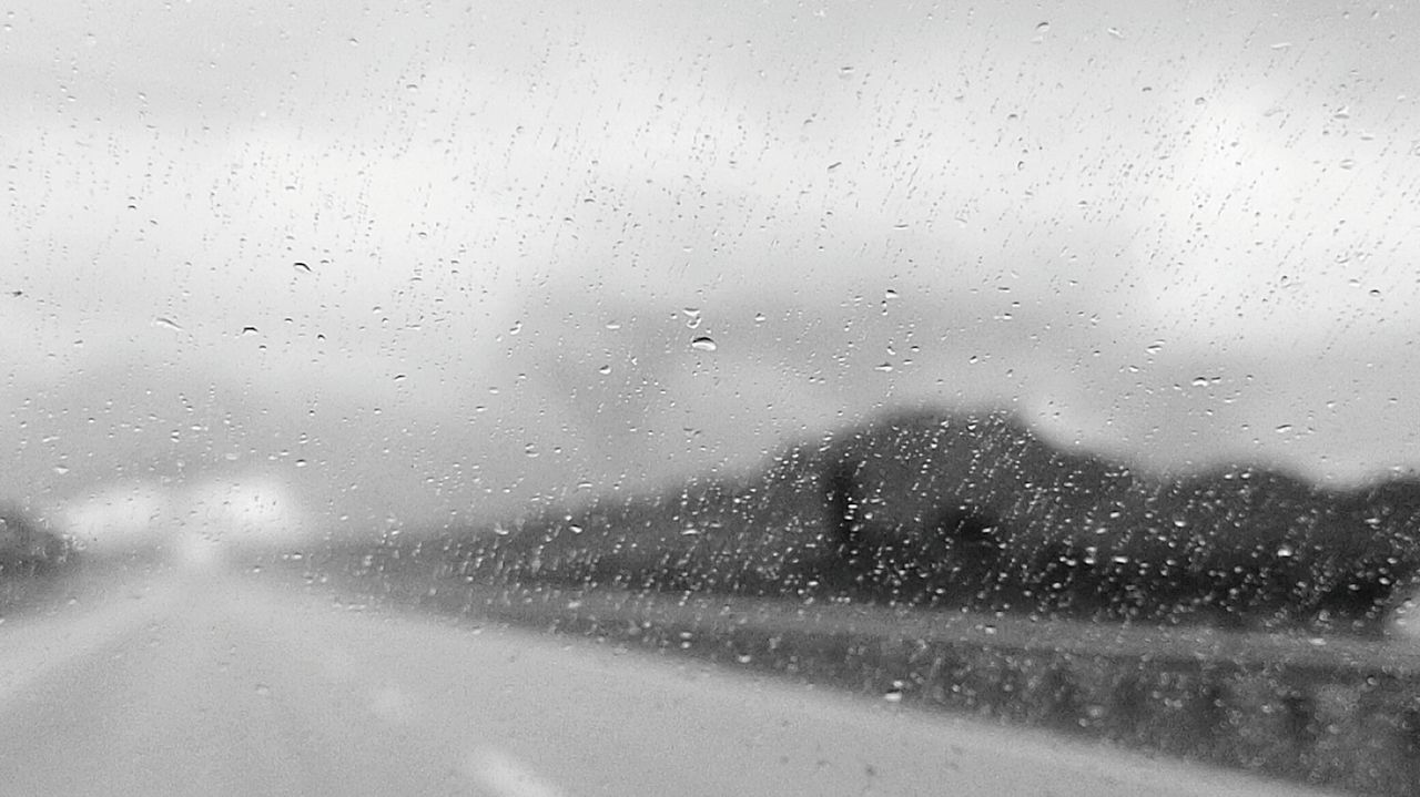 Full frame shot of wet window during rainfall seen through car