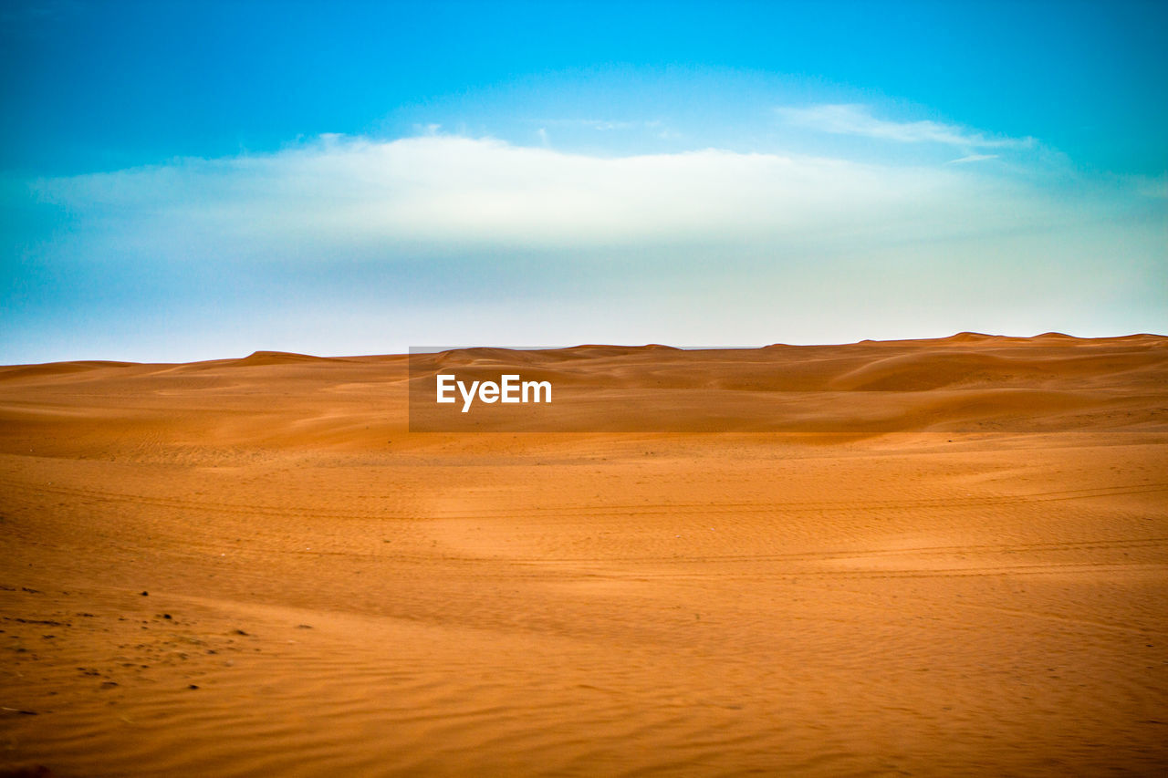 Scenic view of desert against blue sky