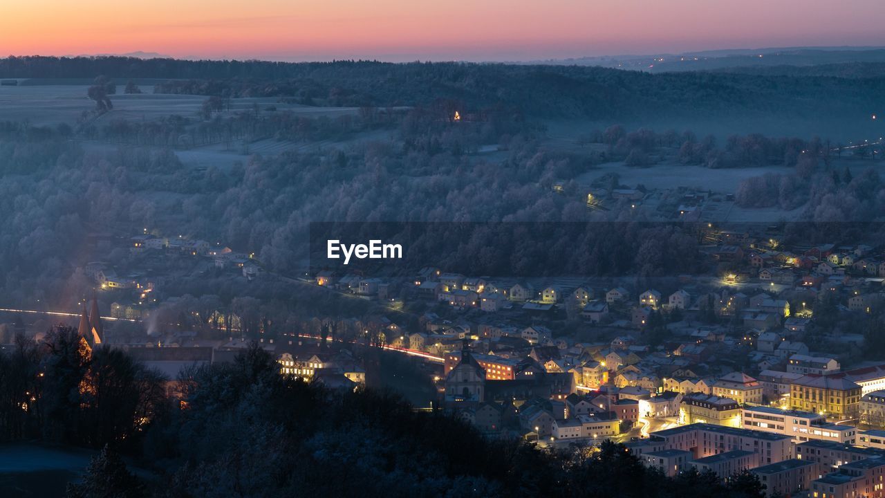 Aerial view of illuminated cityscape against sky at night