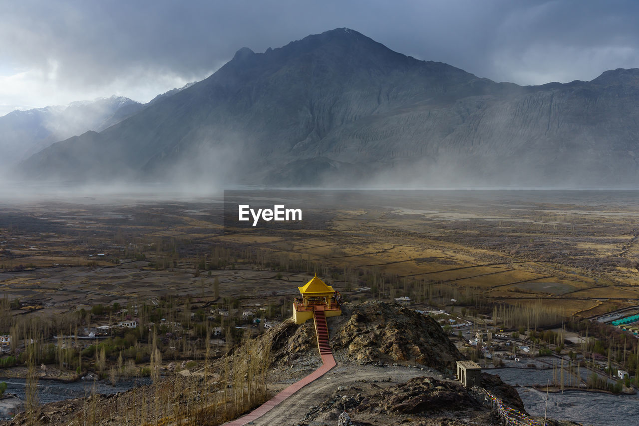 Aerial view of temple building against mountain during foggy weather