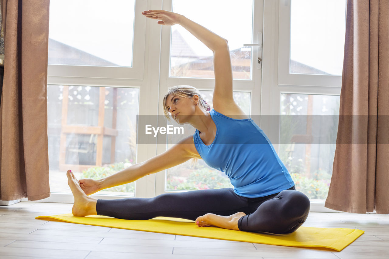 full length of woman exercising at gym