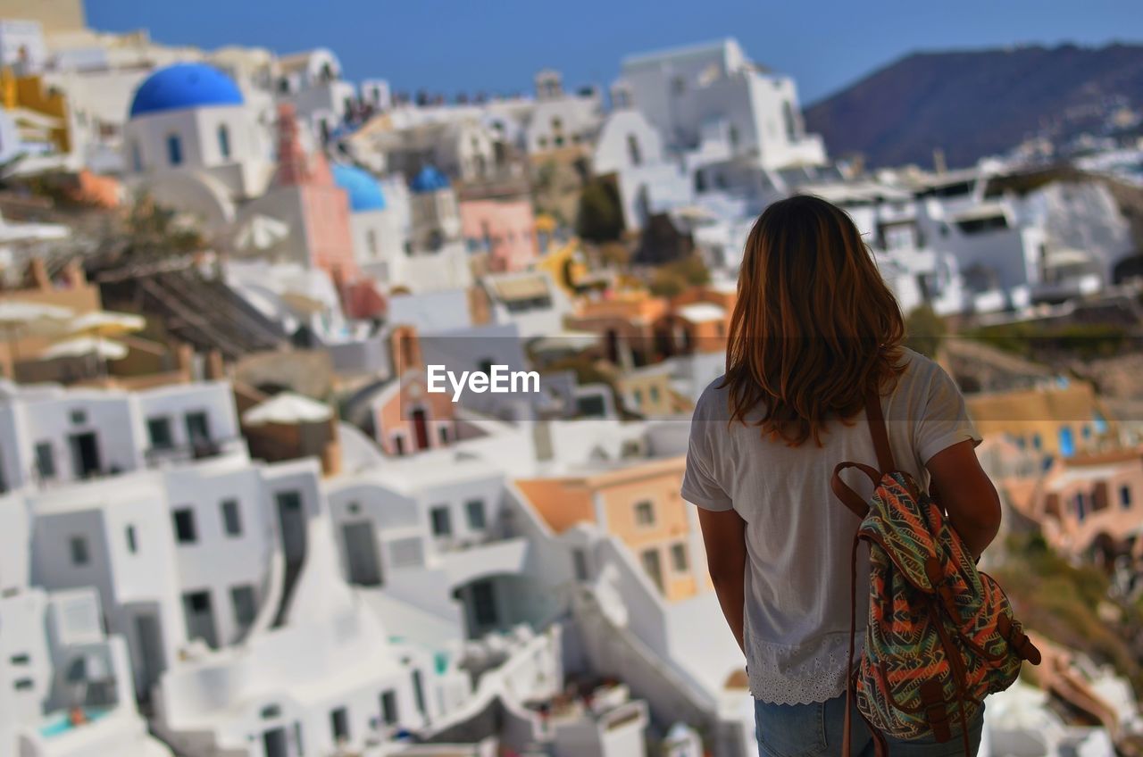 Rear view of woman standing against santorini