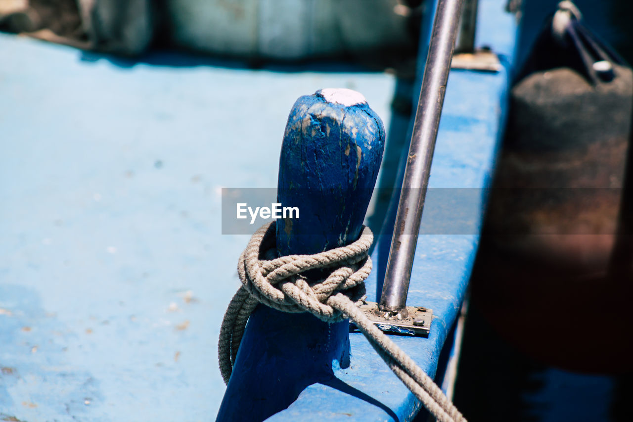 CLOSE-UP OF ROPE TIED UP ON METAL
