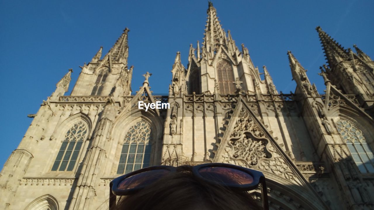 LOW ANGLE VIEW OF STATUE AGAINST TEMPLE