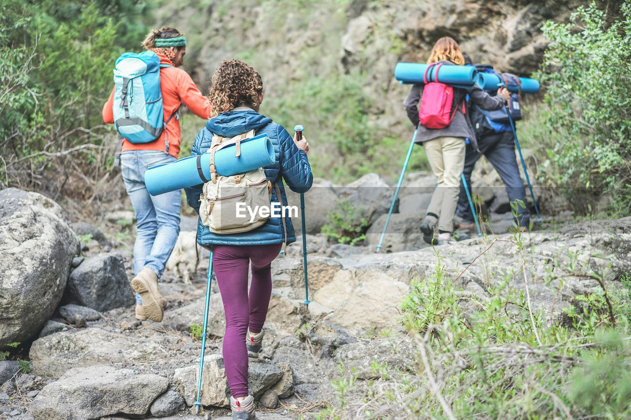 Rear view of people walking on rocks