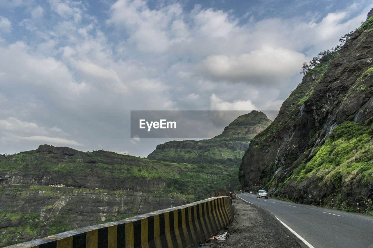 EMPTY ROAD BY MOUNTAIN AGAINST SKY