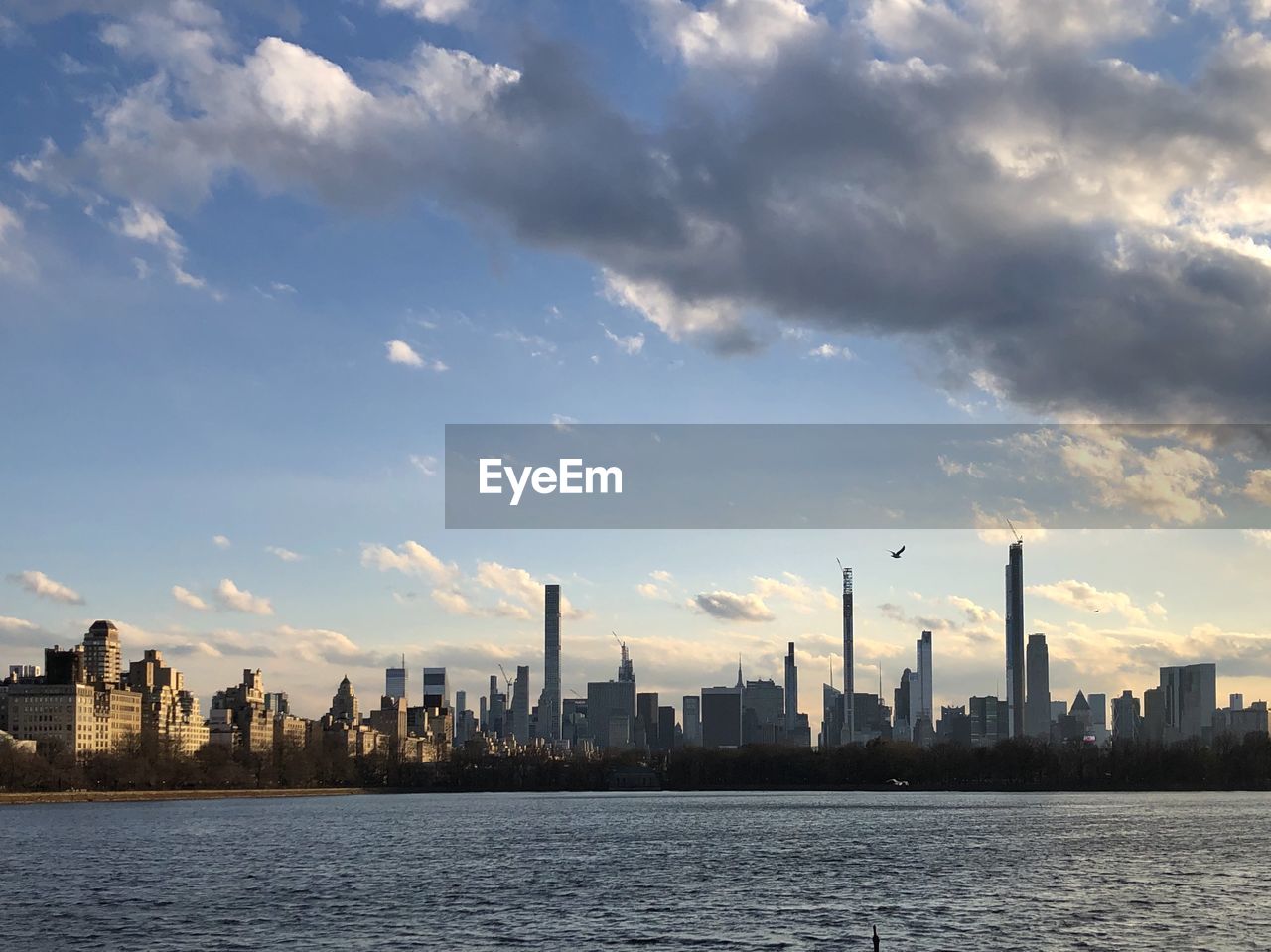 SCENIC VIEW OF RIVER BY BUILDINGS AGAINST SKY IN CITY