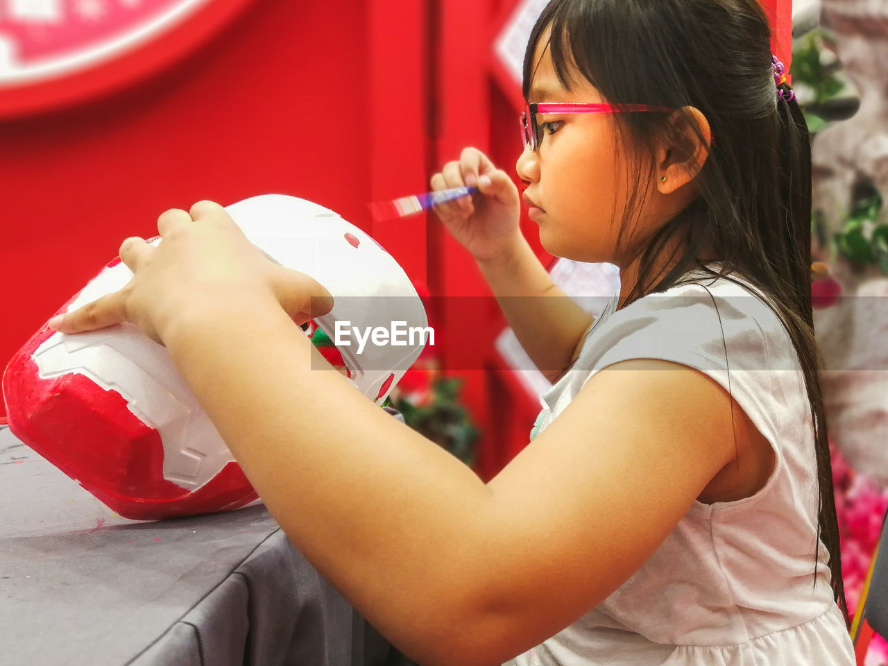 Close-up of cute girl painting craft product 