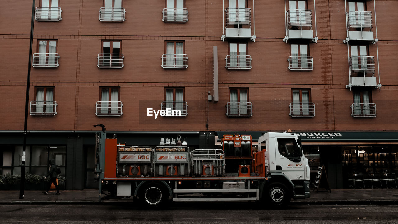 VEHICLES ON ROAD BY BUILDING