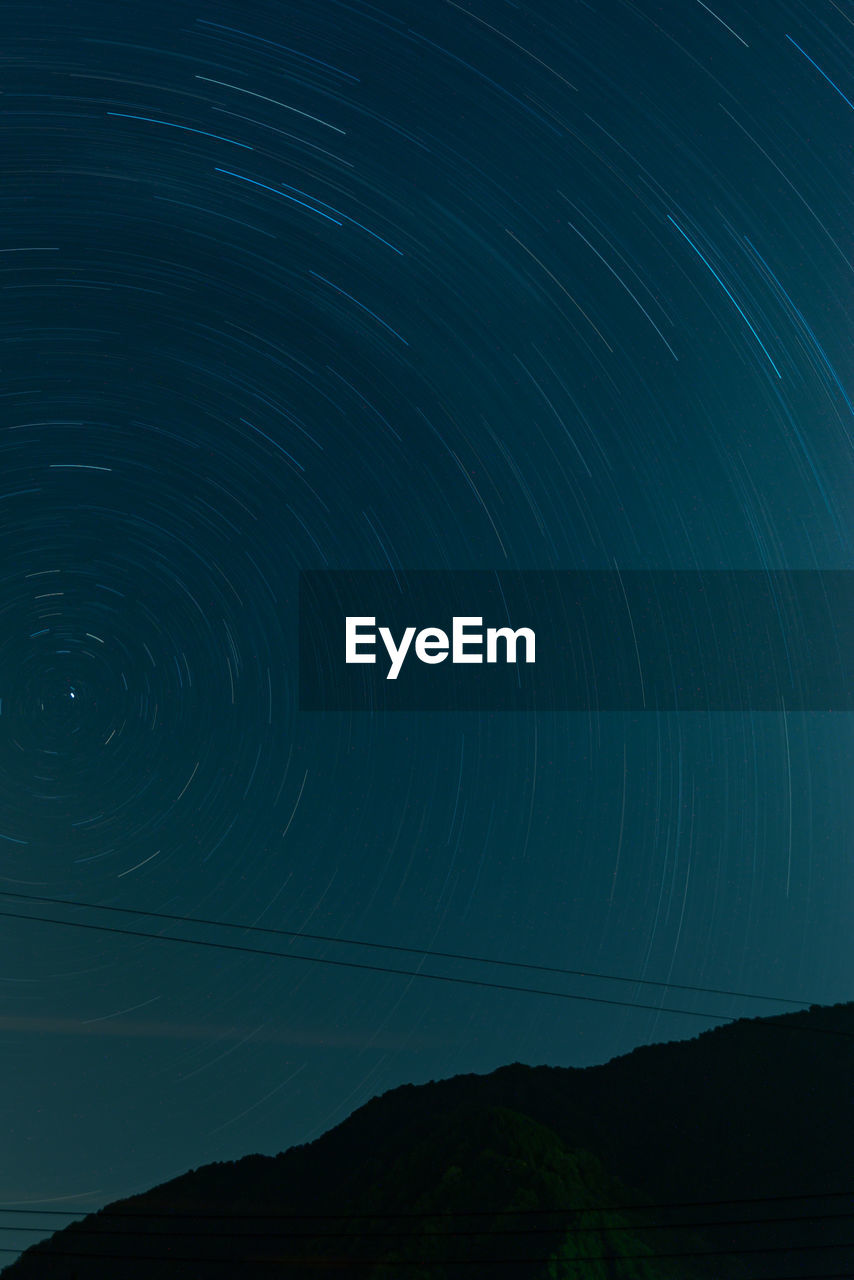Low angle view of star trail against sky at night