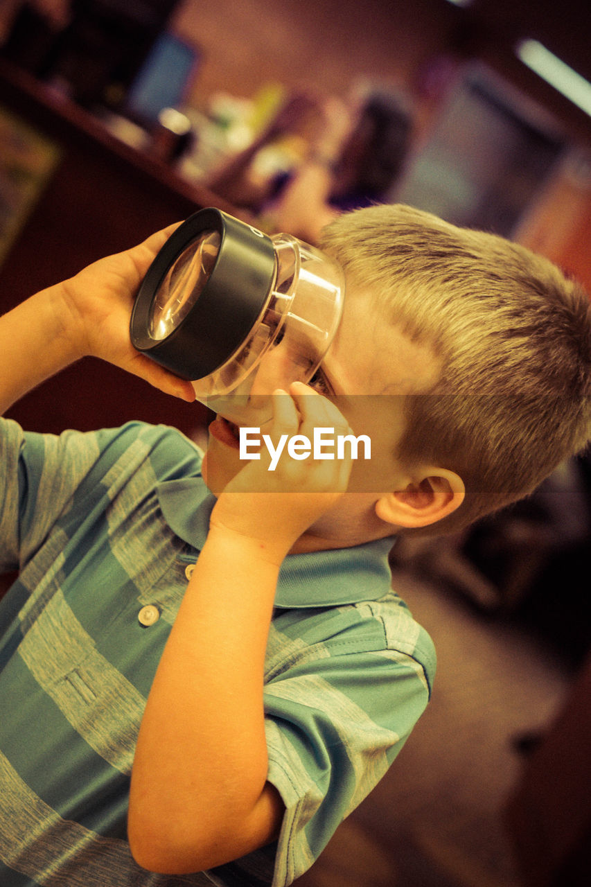 Close-up of boy using old-fashioned magnifying glass