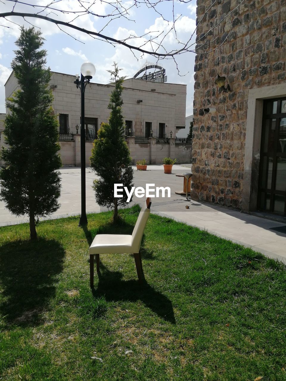 EMPTY BENCH IN PARK BY BUILDING