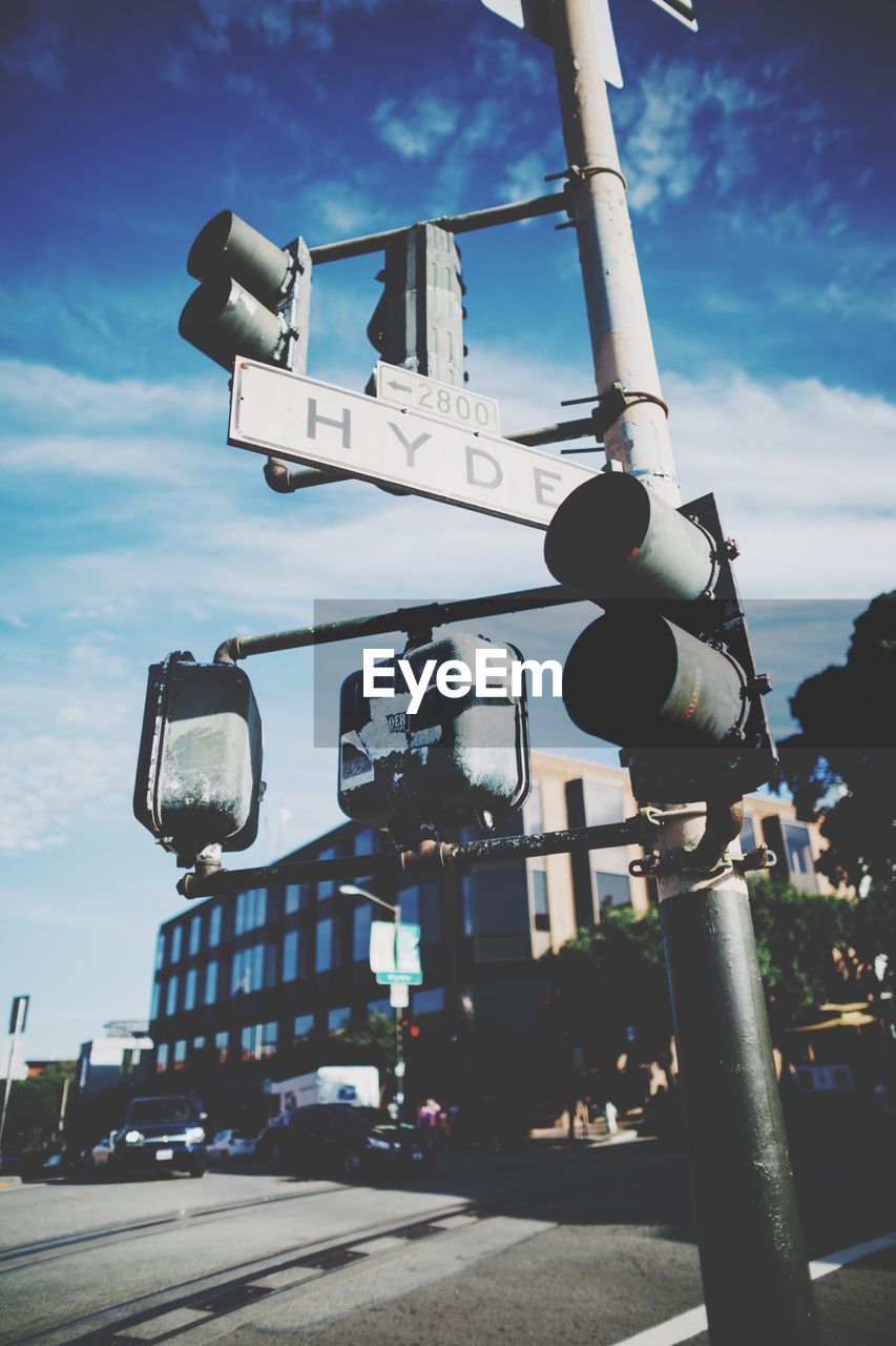 Low angle view of road signal with signboard in city