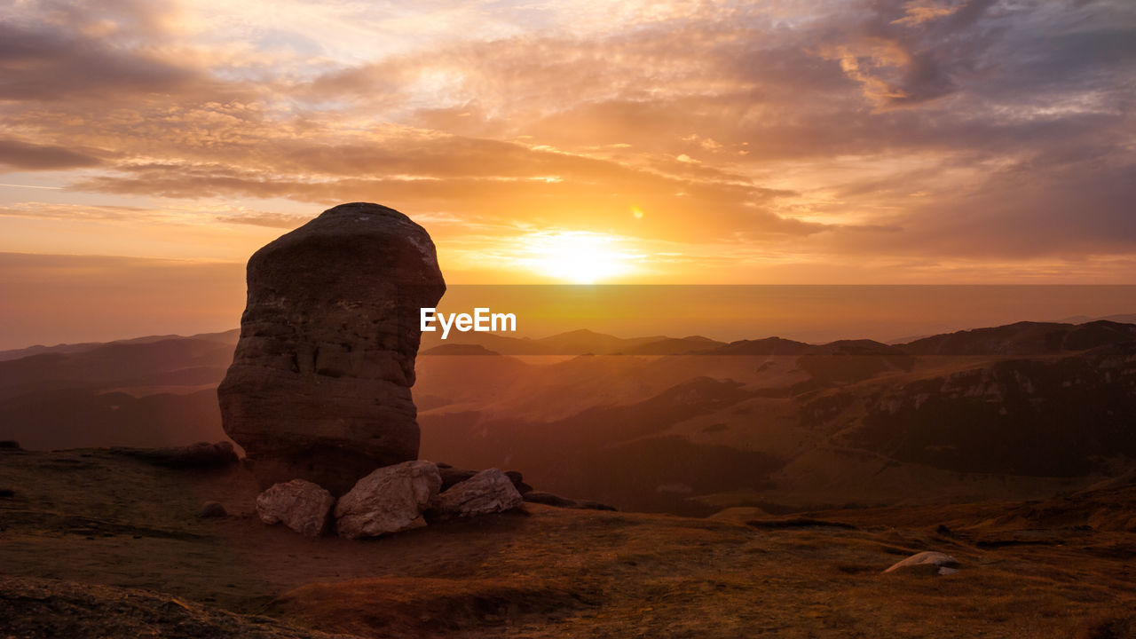 Rock formation against sky during sunset