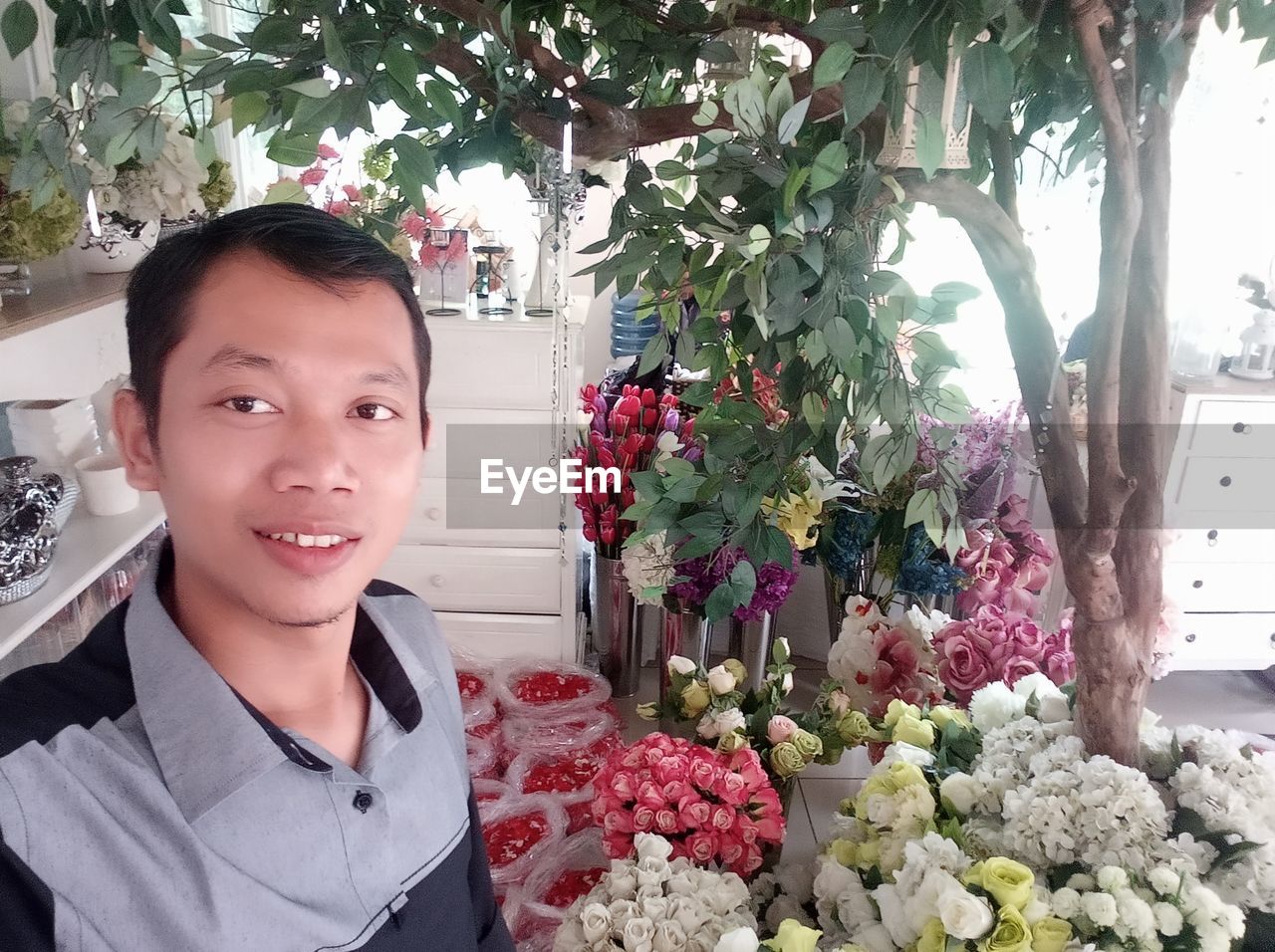 Portrait of man by flower bouquets in market