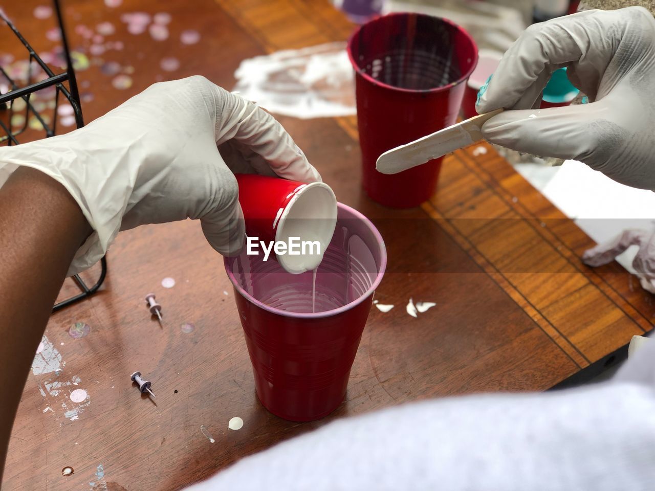 High angle view of people preparing acrylic paint on table