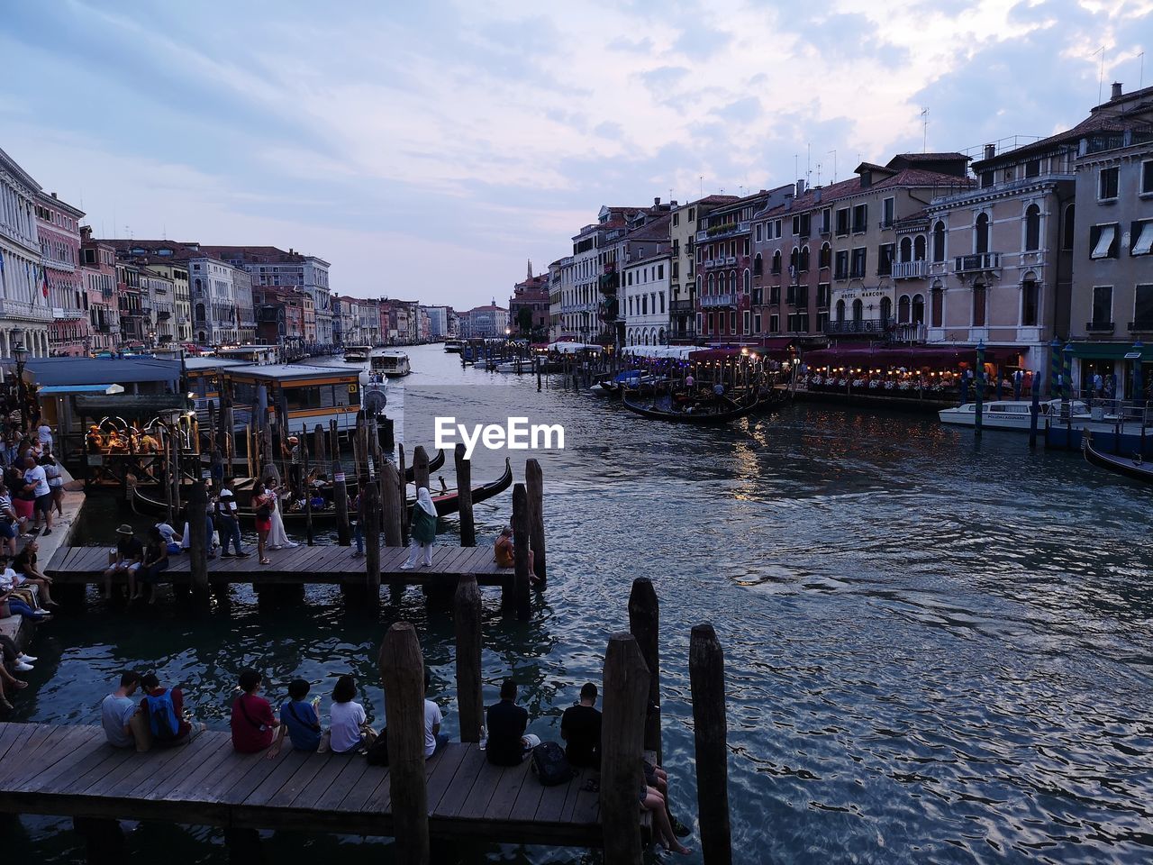 BOATS IN CANAL AMIDST BUILDINGS AGAINST SKY IN CITY