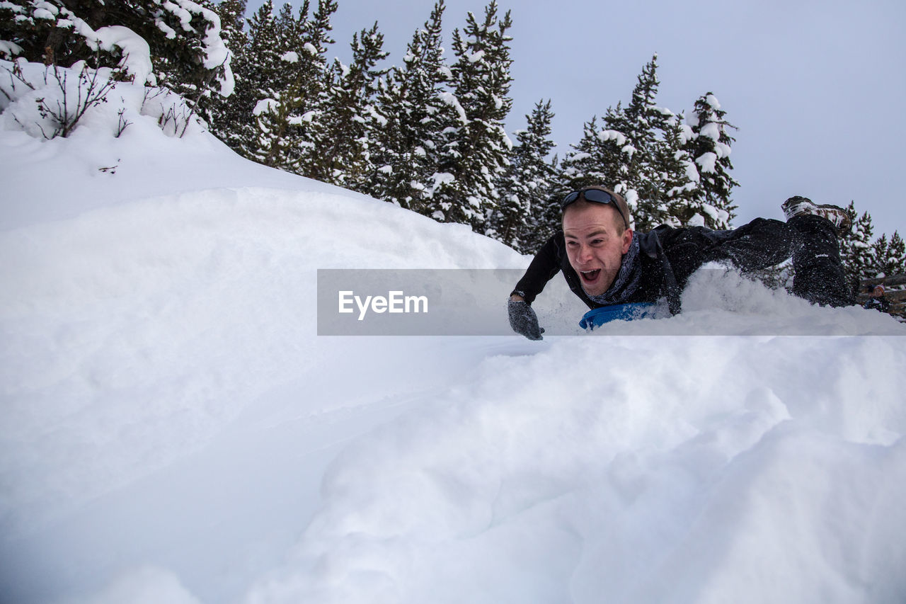 MAN IN SNOW COVERED TREES