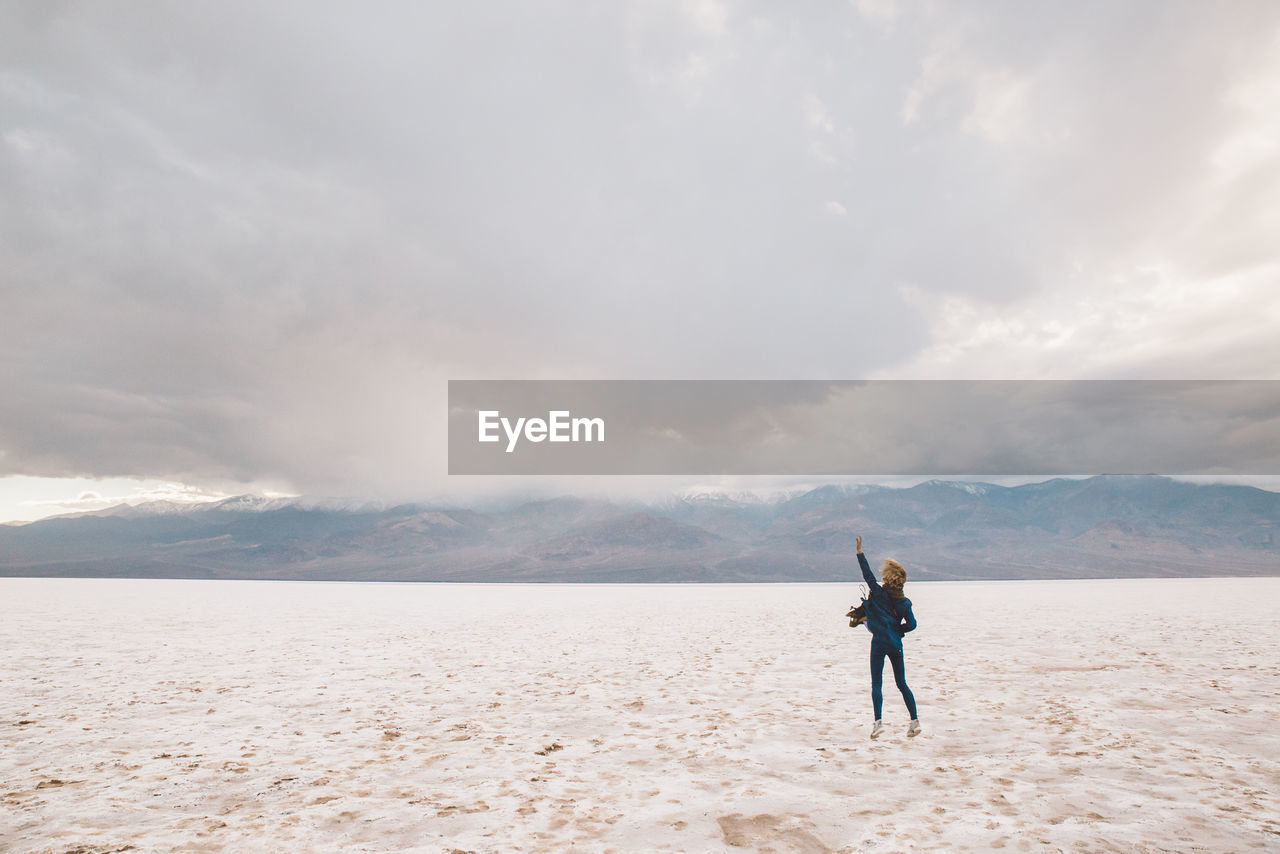 Rear view of woman standing on sand at death valley national park