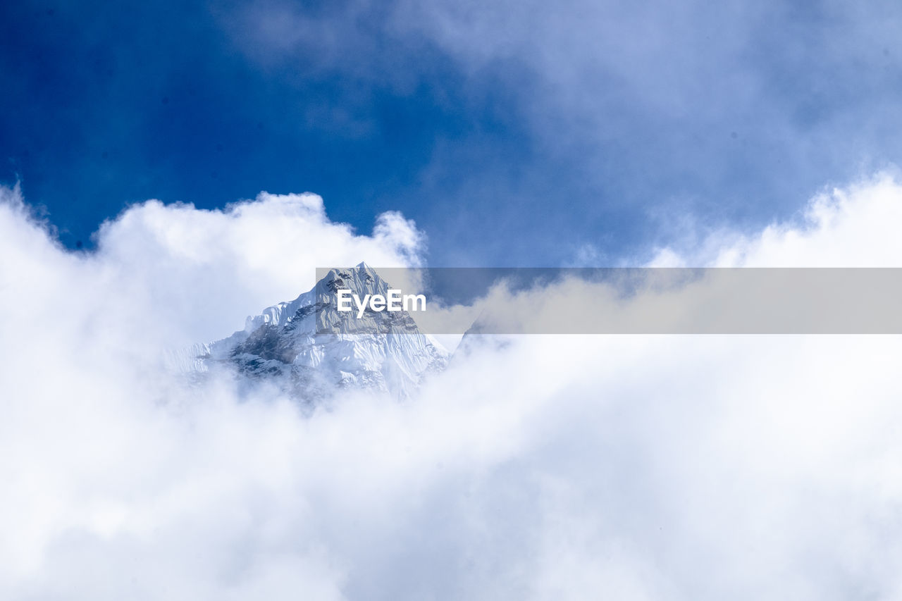 Low angle view of snowcapped mountains against sky