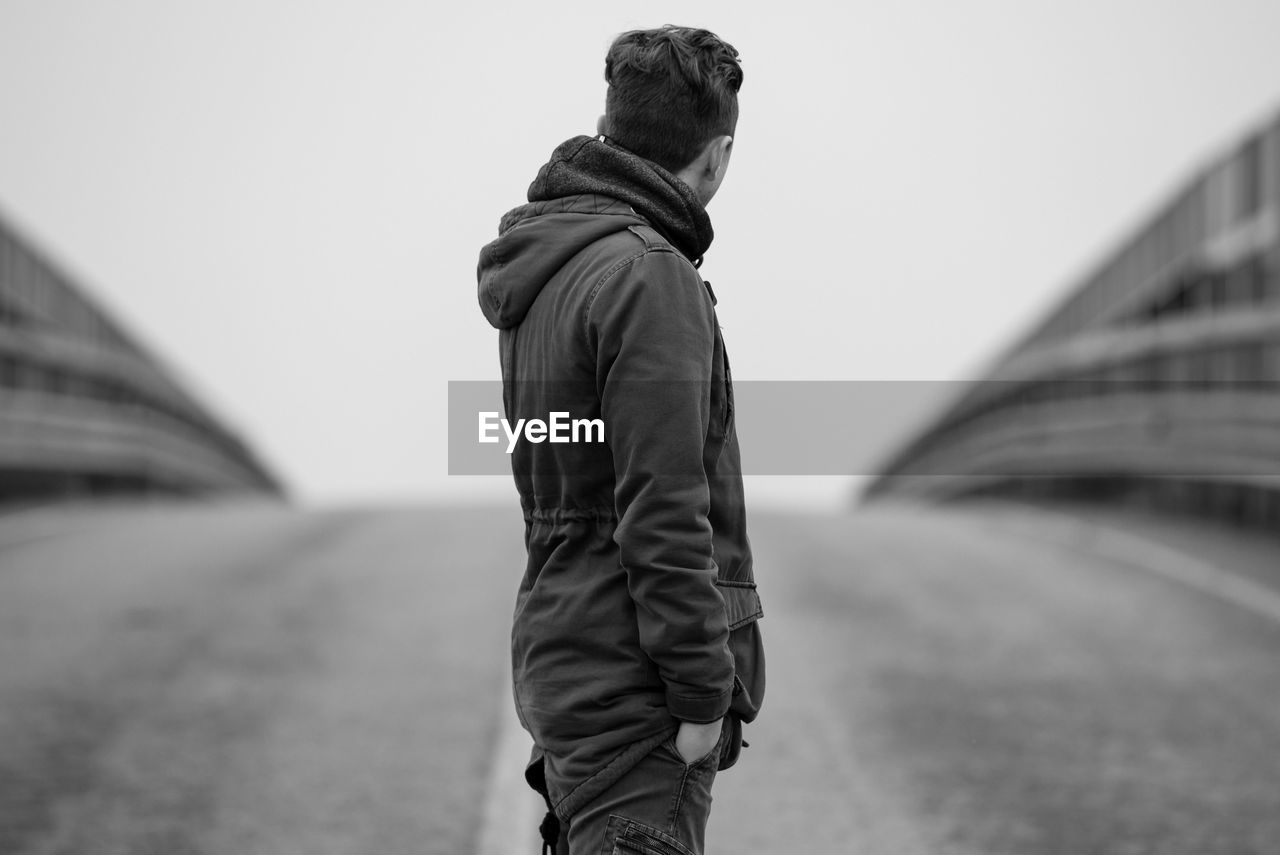 Man standing on road against clear sky