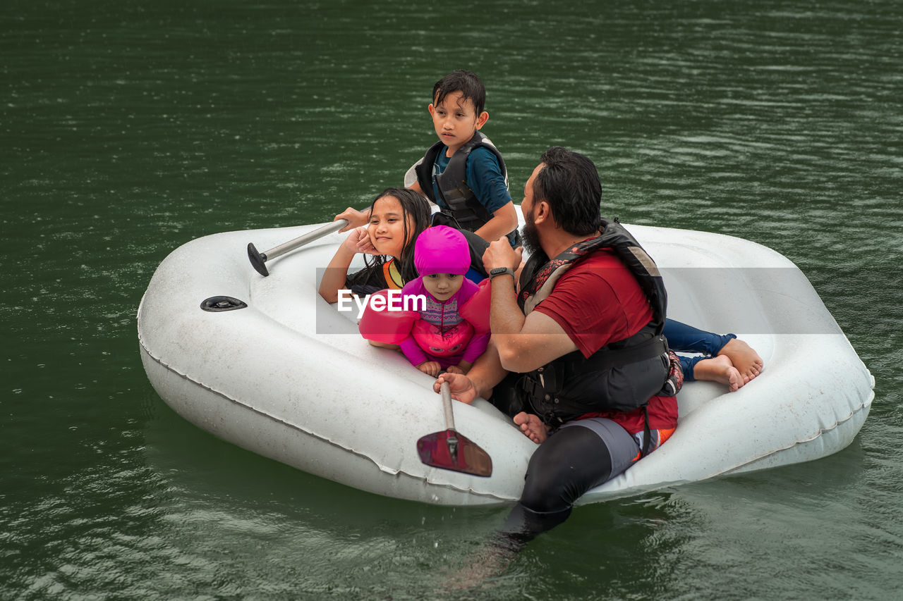 Man with children floating on lake