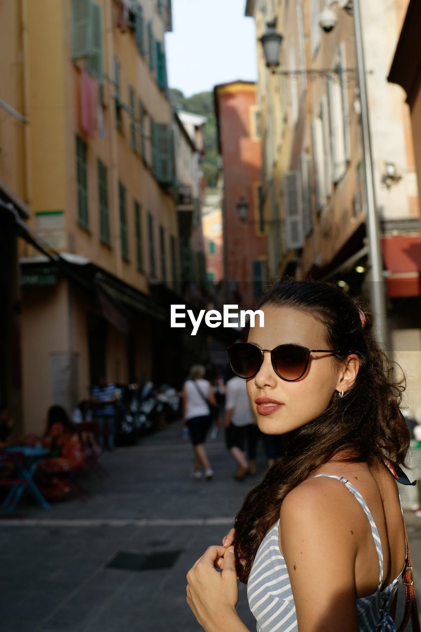 Portrait of young woman wearing sunglasses in city
