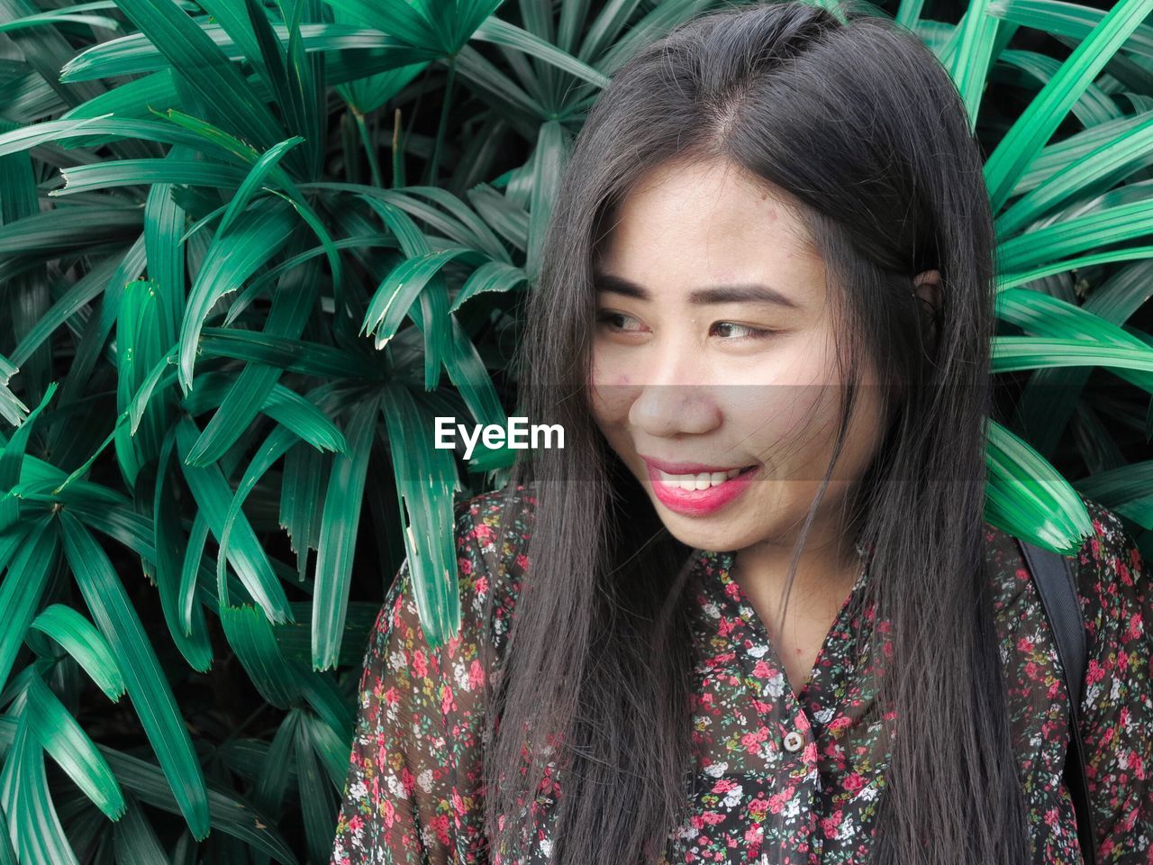 Close-up of smiling woman by plants